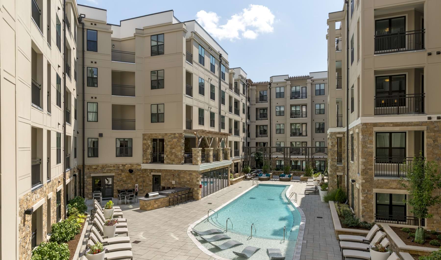 Resort-style swimming pool with lounge seating and apartment views
